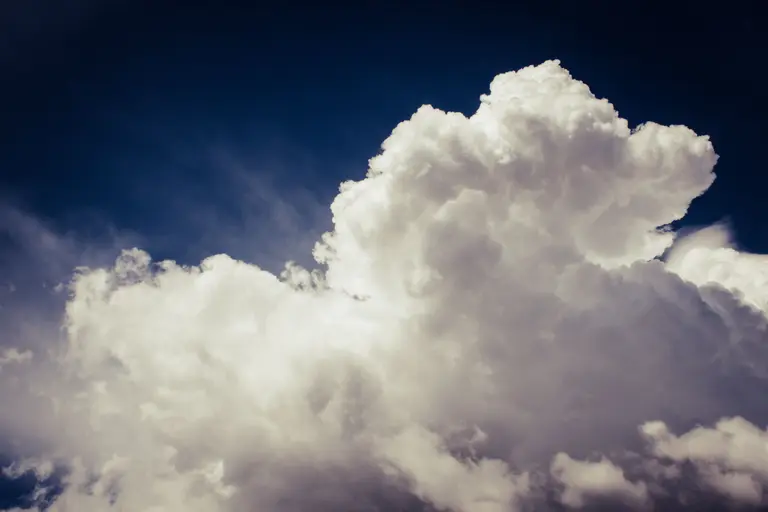 A white cloud in a dark blue sky